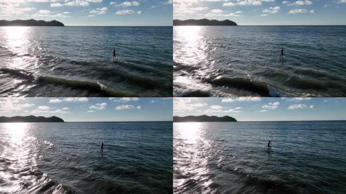 女性站立桨板冲浪者 (SUP) 的鸟瞰图在海浪中冲浪