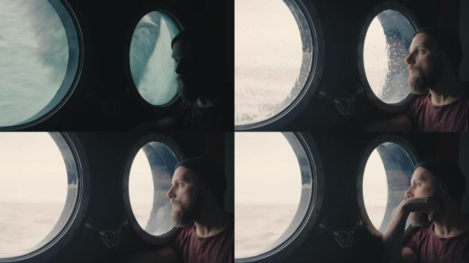 一艘航行在海洋中的船的舷窗处的人