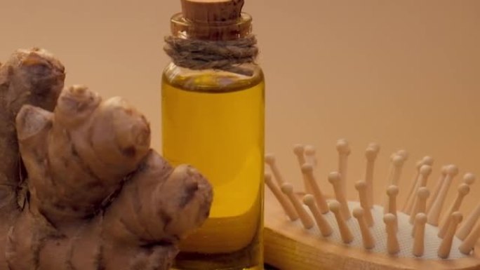 玻璃瓶的基本姜油，姜根在米色背景。健康的另类生活。用于头发护理的天然化妆品成分。健康生态梳子自制发膜