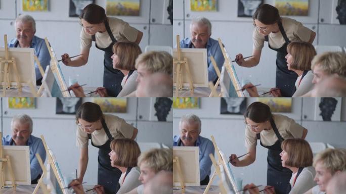 与退休的男女一起在绘画课上作为娱乐活动或疗法时微笑着快乐的老年人的侧视图