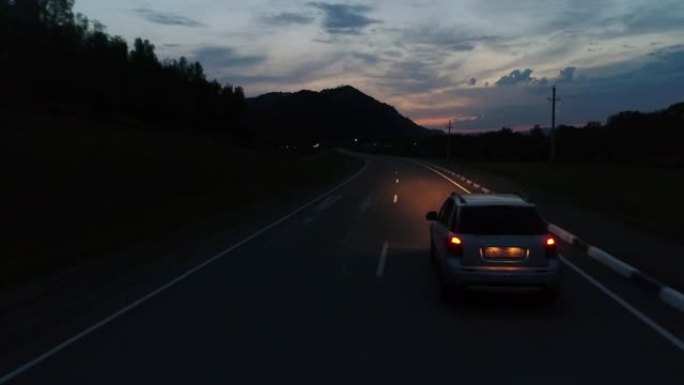 黎明时在山区公路上跟随汽车行驶