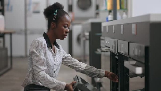 美国黑人家庭主妇在家用电器商店购买电烤箱，女性购物者正在比较展览样品