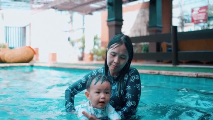 快乐的妈妈和儿子在游泳池里玩耍