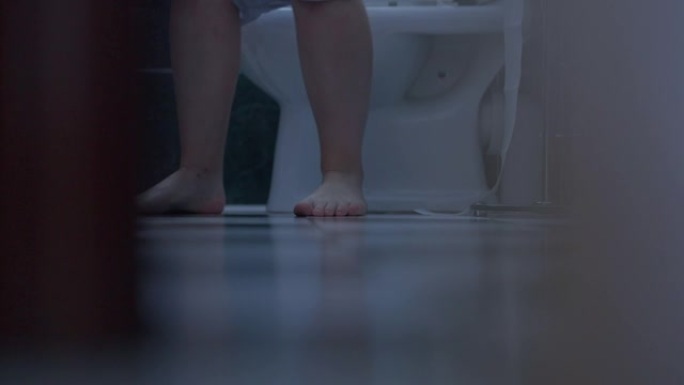 赤脚的白人男性双腿进入厕所，坐下来脱下内裤，轻拍脚。无法辨认的男人早上在家使用浴室。常规和卫生概念。
