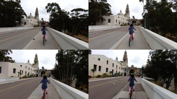 一名妇女骑着自行车穿过城镇的镜头