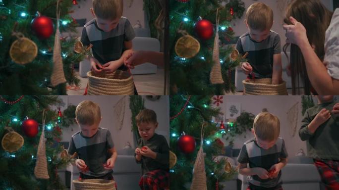 双胞胎男孩和他们的妈妈一起选择玻璃球来装饰圣诞树