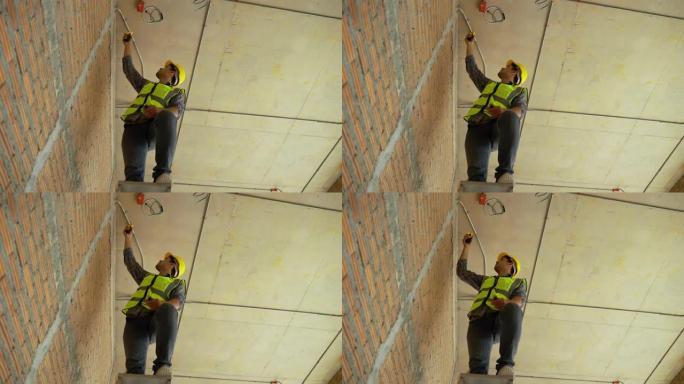 建筑工人正在爬梯子检查建筑物中的电气系统。
