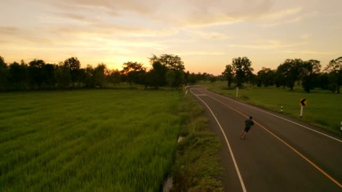 鸟瞰图，他在暮光之城的户外道路上玩直排轮滑。