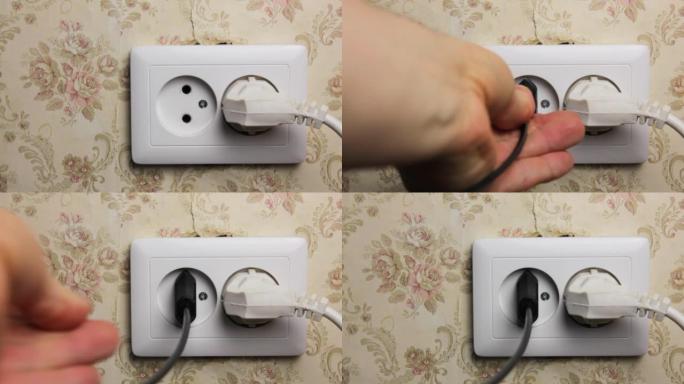 一名男子将插头插入墙上的电插座close-up.Old电插座。
