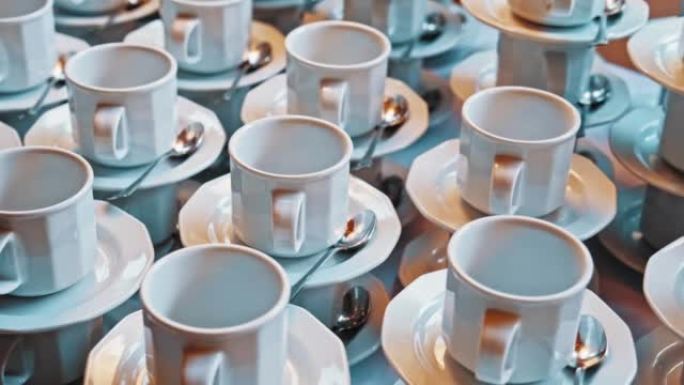 桌子上摆满了为会议参与者准备的空白瓷咖啡杯和茶碟婚礼客人