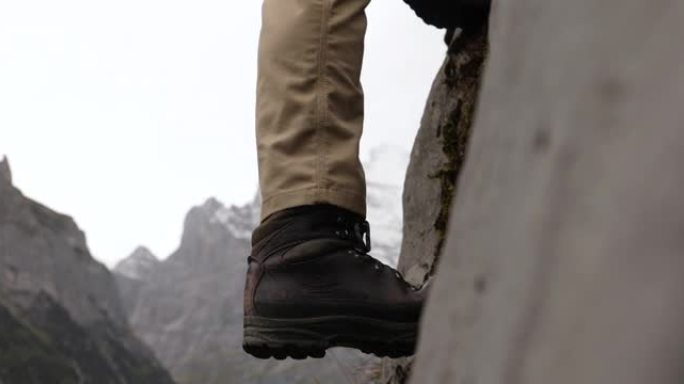 男性登山者登上陡峭的岩石面