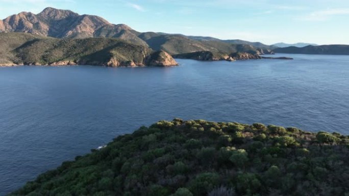 日落时飞越多山的海岸线，可以看到大海、悬崖和绿色的田野。