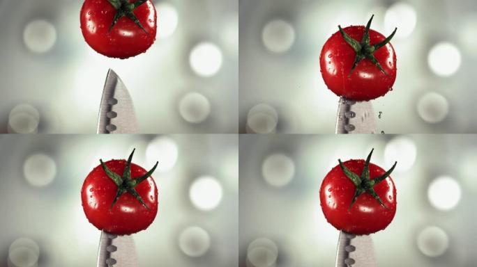 新鲜番茄落在刀子上。白色波克厨房。慢动作。