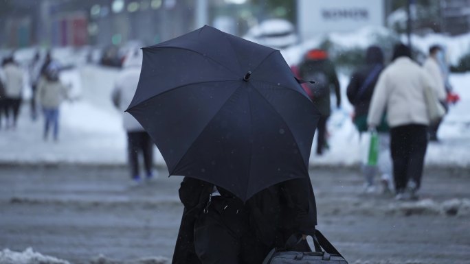 城市奋斗者在风雪中艰难行走