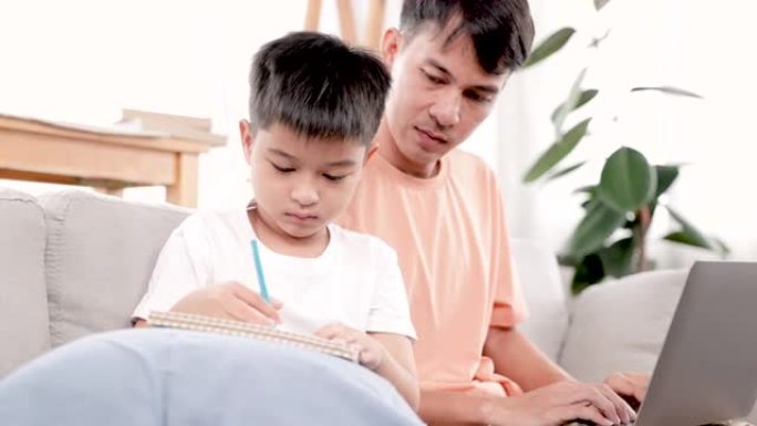 4K，一个亚洲单身父亲和儿子坐在房子的沙发客厅上，给图纸上色，父亲教我如何选择颜色与图纸搭配，父亲正