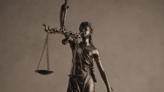 正义是被蒙住眼睛的青铜法律雕像，剑和平衡在棕色背景前旋转，说明权力和权利的概念