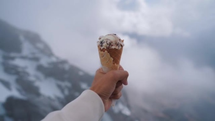在雪山峰上拿着冰淇淋