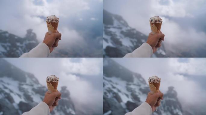 在雪山峰上拿着冰淇淋