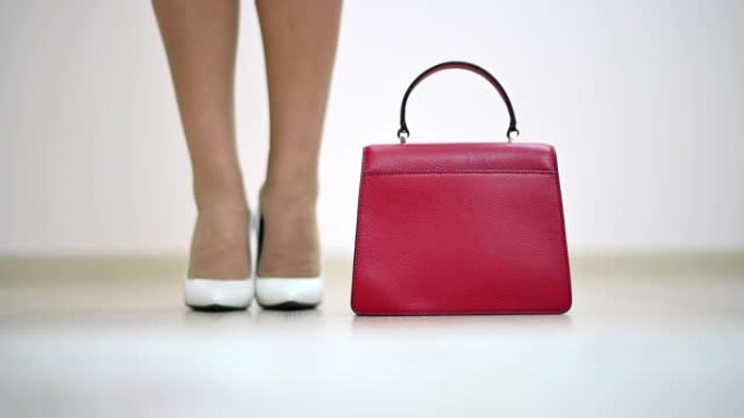 女人穿上白色鞋子和红色钱包