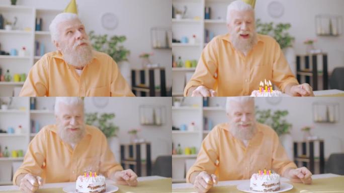 老人在生日蛋糕上吹蜡烛，许愿，孤独的爷爷