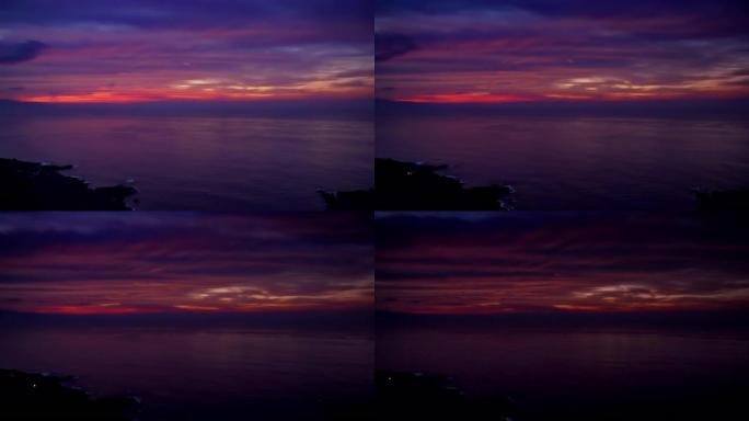 狂野的海洋海岸线，背景中的日落。戏剧性的，紫色的天空