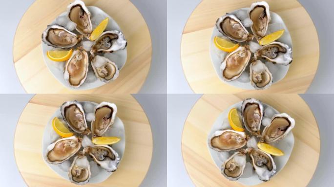 冰上牡蛎配柠檬特写。餐厅大盘子半壳新鲜牡蛎。上桌。4K UHD视频慢动作