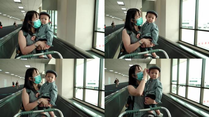 母亲和儿子在机场航站楼使用自动扶梯和行李车