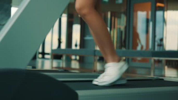亚洲妇女在健身房的跑步机上锻炼