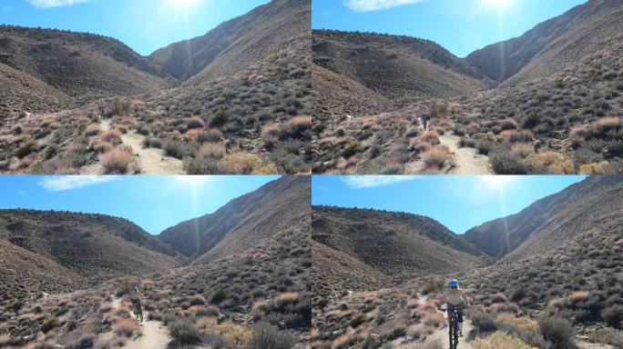 一名男子山地自行车手沿着狭窄的沙漠轨道行驶