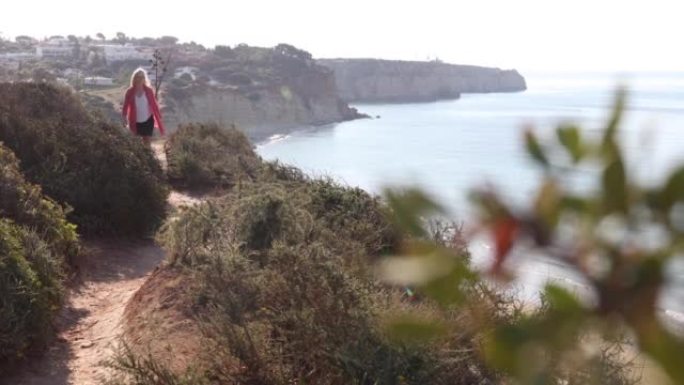 成熟的女人沿着沿海悬崖的边缘行走