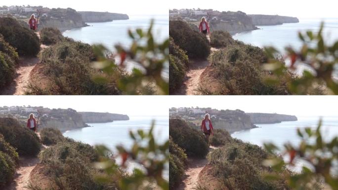成熟的女人沿着沿海悬崖的边缘行走