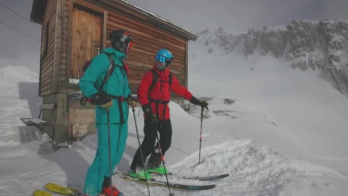 两名滑雪者用滑雪杖指向斜坡