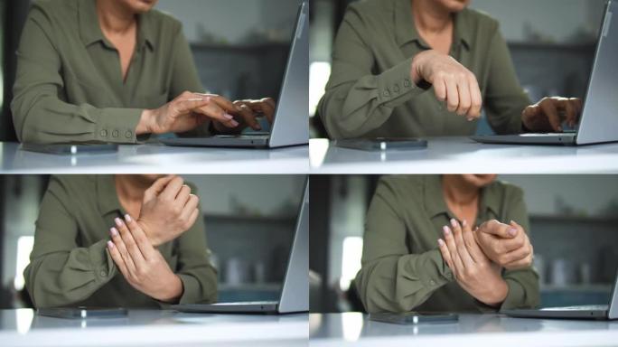 女人在笔记本电脑上打字停止和按摩麻木的手腕，腕管综合症