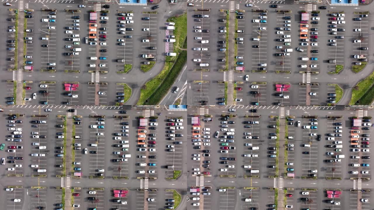 停放在停车场上的许多彩色汽车的鸟瞰图，带有用于停车地点和方向的线条和标记。
