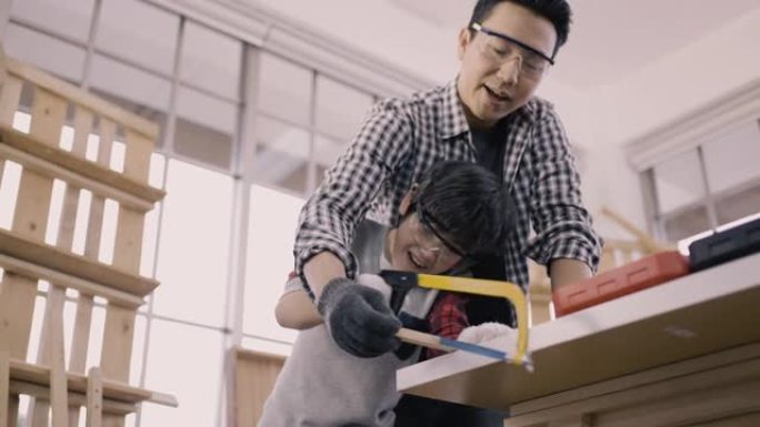 父亲帮儿子用手蜡切木板