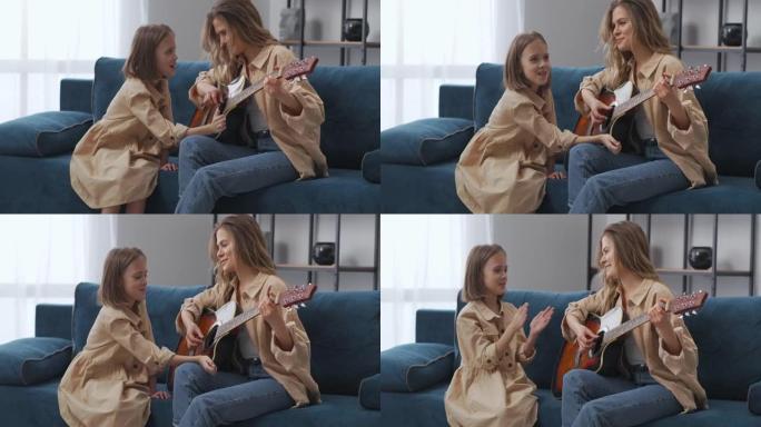 幸福的母女在一起弹吉他，女孩在为女人鼓掌