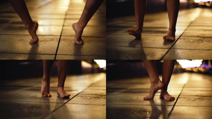 年轻女子在潮湿的城市街道上表演自由式舞蹈。赤脚特写
