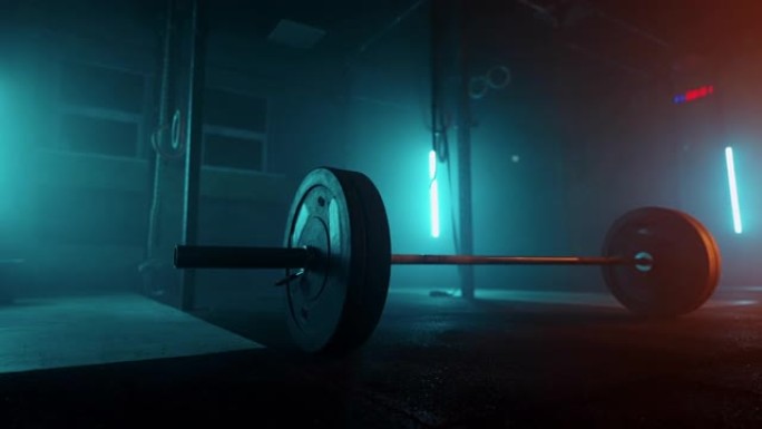 黑暗运动场地板上的杠铃，用于健美运动员和举重运动员的训练