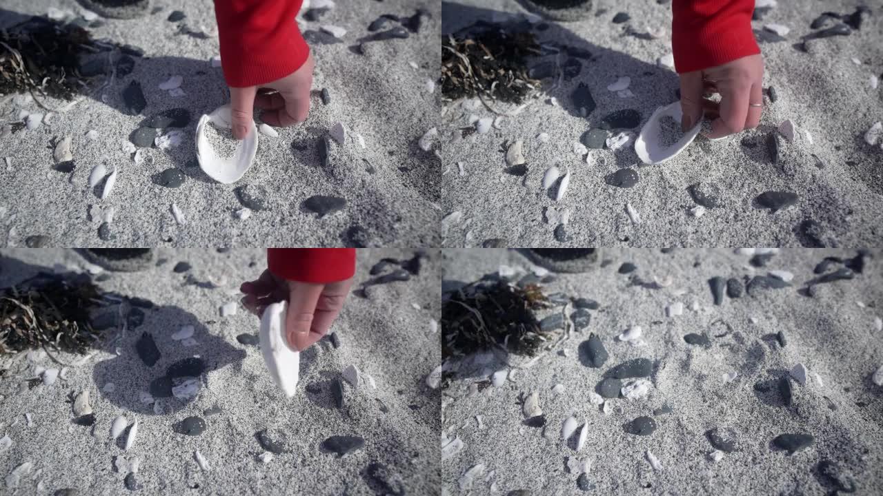 一个女人在海滩上捡起贝壳的细节镜头