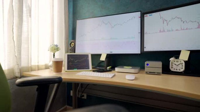 没有人家庭办公室设置。桌子上有一个电脑显示器和一个供股票投资者使用的平板电脑。在房子的卧室里。
