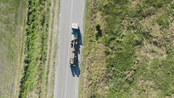 在当地城市道路上运送农业设备的货车的俯视图