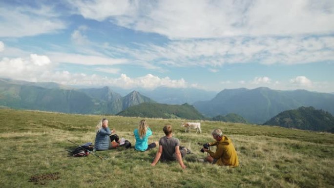 一家人躺在山上的草木山坡上休息一下，养着牛