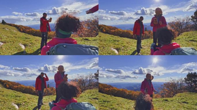 SLO MO徒步旅行者在阳光明媚的山顶上拍照