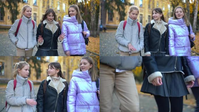 追踪三个积极的女性青少年同学课后闲聊的镜头。美丽快乐的高加索女学生在校园里散步。实时摄像机跟随学生。