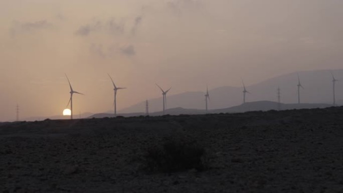 风力涡轮机剪影。干旱气候下的日落