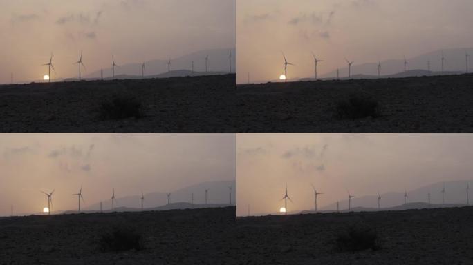 风力涡轮机剪影。干旱气候下的日落