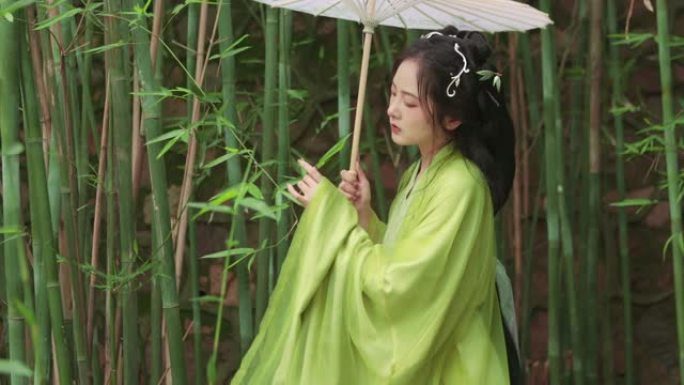 汉服美女在竹林里拿着油纸伞