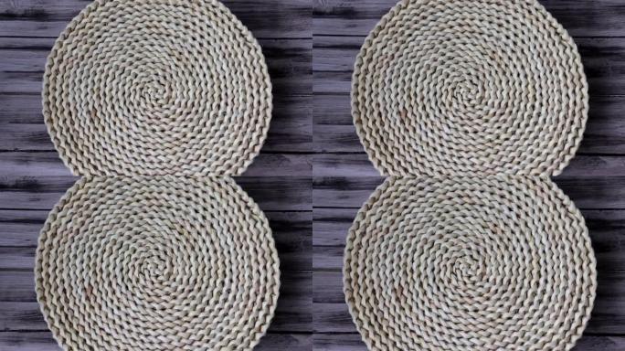 木制背景上的厨房用水葫芦纤维制成的圆形编织风信垫地毯。