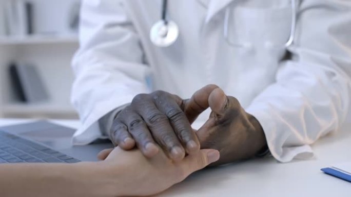 专业非裔美国医生安慰病人，抚摸手，支持