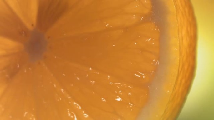 一滴水从成熟多汁的柠檬片表面流下。慢动作4K
